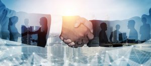 Business partners shaking hands over city landscape