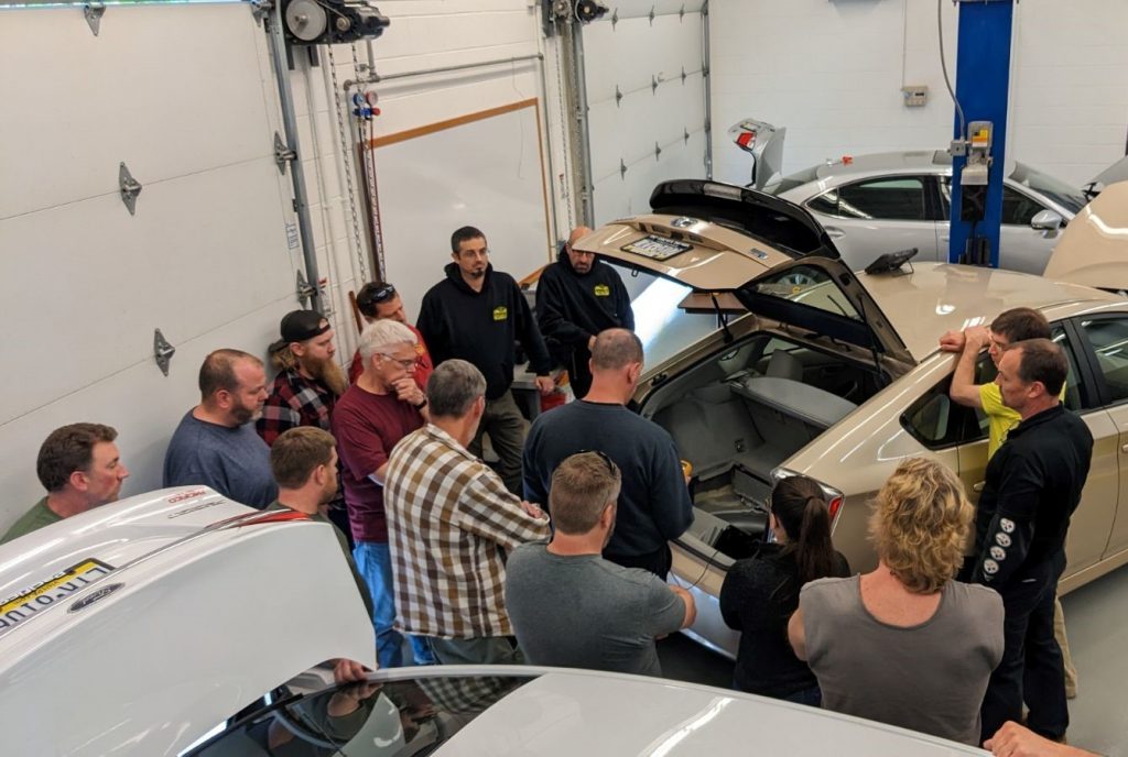 Group of people looking at the trunk of an electric vehicle at an EVPRO+ Training session