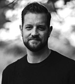 Ryan Maguire, CEO of Helm, in a black and white outdoor portrait, featured author of a guest article on MOTOR.com.